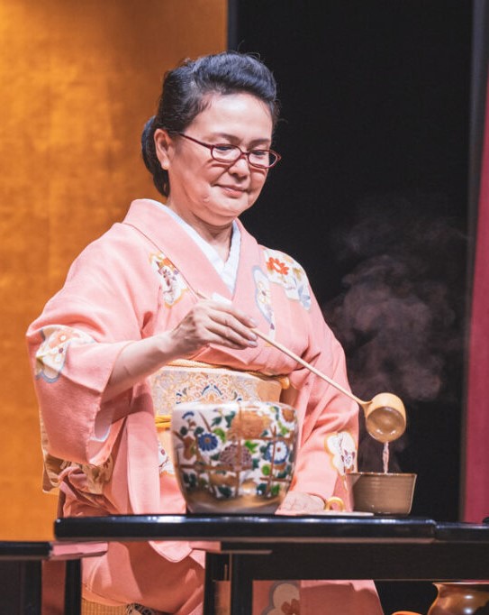 Japanese woman pouring hot tea into bowl